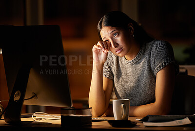 Buy stock photo Shot of a young businesswoman looking stressed out while working on a computer in an office at night