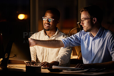 Buy stock photo Shot of two businessmen working together on a computer in an office at night