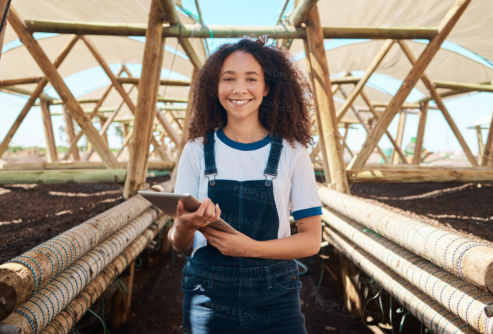 Buy stock photo Portrait of a young woman using a digital tablet while working on a farm