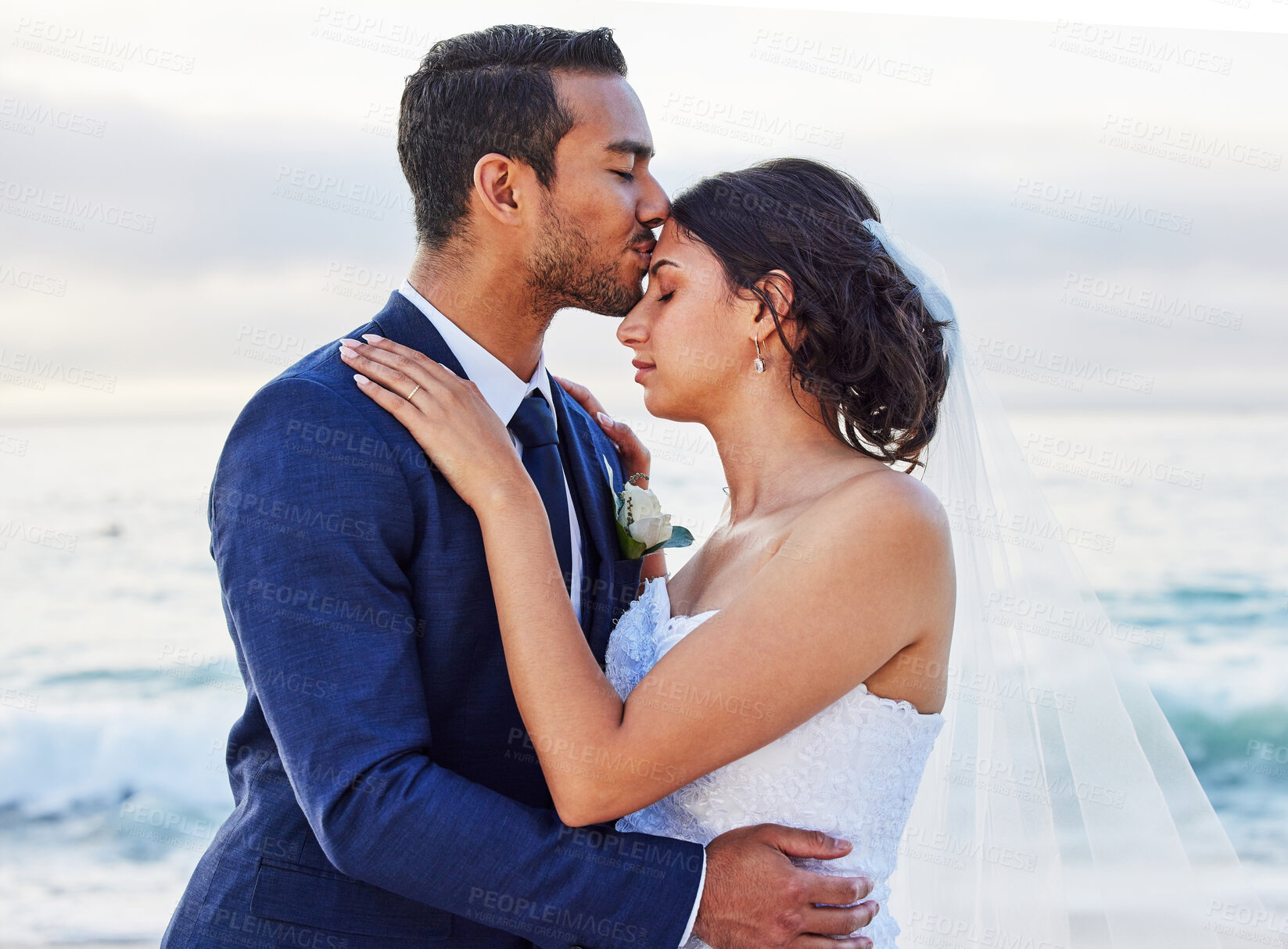 Buy stock photo Shot of a young couple on the beach on their wedding day