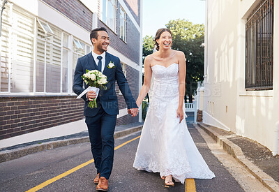 Buy stock photo Shot of a beautiful couple walking in the city on their wedding day