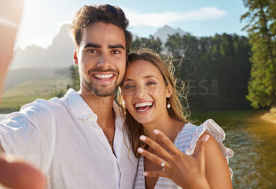 Buy stock photo Shot of a young couple taking a selfie after getting engaged