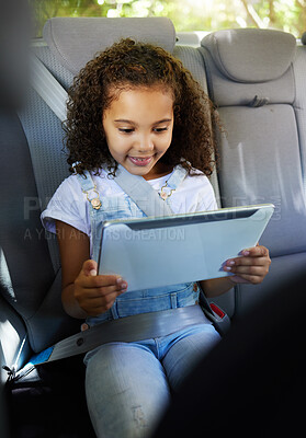 Buy stock photo Happy, watching and a child in a car with a tablet for a movie, cartoons or video. Smile, travel and a girl sitting in a vehicle with tech, streaming online and enjoying a film for entertainment