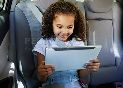 Buy stock photo Happy, car and girl with tablet, safety and streaming cartoons with happiness, relax and apps. Young person, female child and kid with device, vehicle and travelling with smile, connection and calm