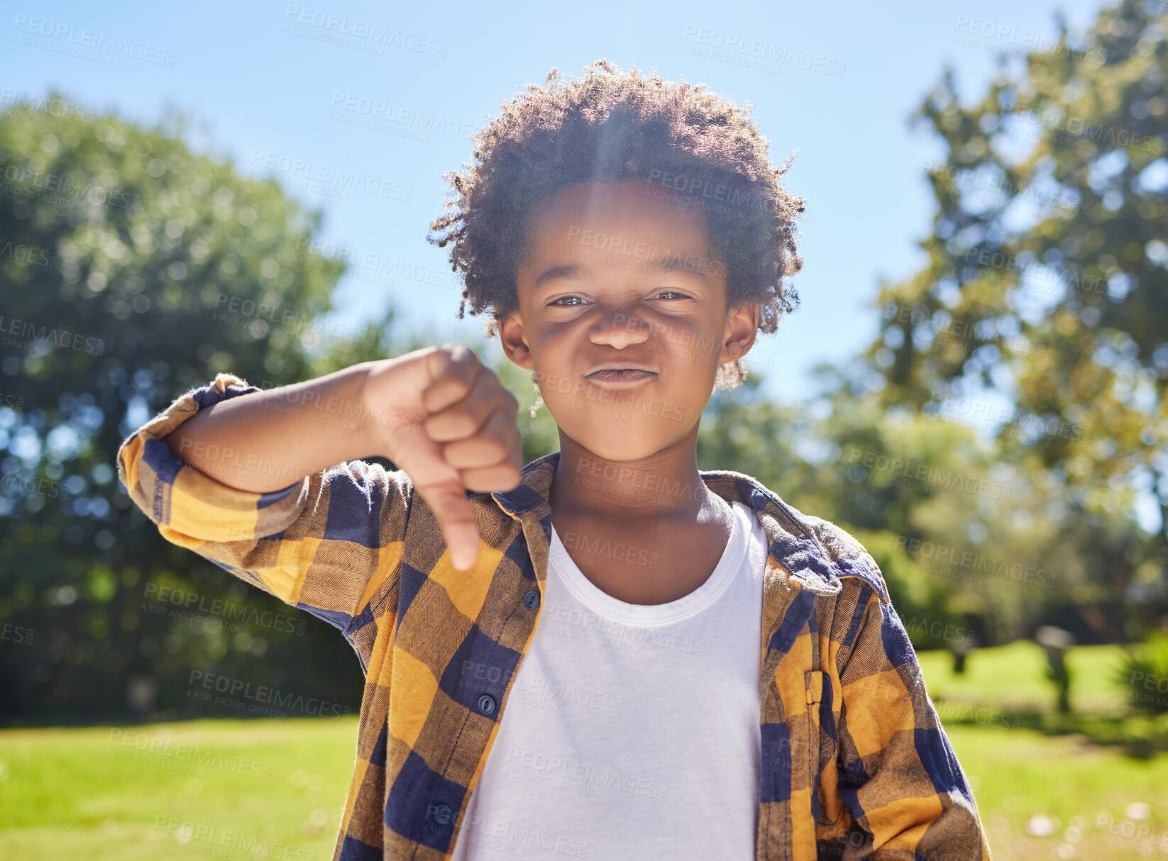 Buy stock photo Thumbs down, portrait or angry child in park unhappy, upset or frustrated in nature. Young African boy kid being negative by disagreeing with wrong sign, poor review or no body language 