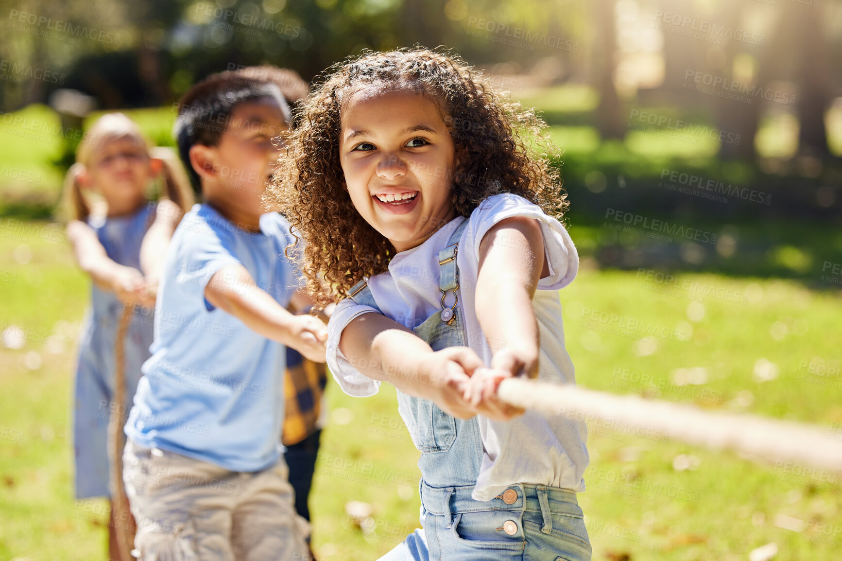 Buy stock photo Funny, games and children playing tug of war together outdoor in a park or playground during summer. Friends, diversity and kids pulling a rope while having fun or bonding in a garden on a sunny day