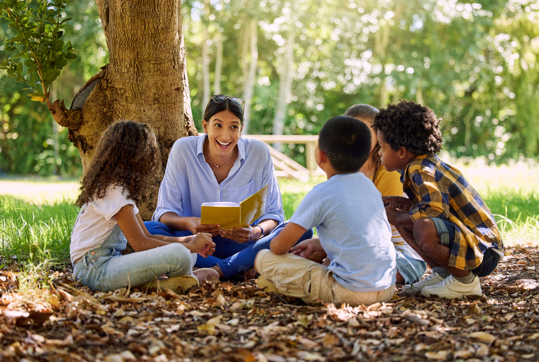 Buy stock photo Teacher reading, tree or children with book for learning development, storytelling or growth in park. Smile, youth or happy educator with stories for education at a kids kindergarten school in nature