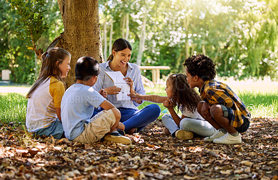 Buy stock photo Books, reading or teacher with children in a park storytelling for learning development or growth. Smile, tree or happy educator with stories for education at a kids kindergarten school in nature