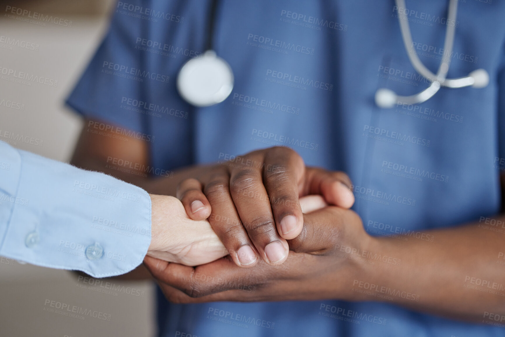 Buy stock photo Shot of two unrecognizable doctors holding hands at a hospital
