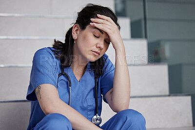 Buy stock photo Shot of a young female doctor looking tired while working in a modern hospital