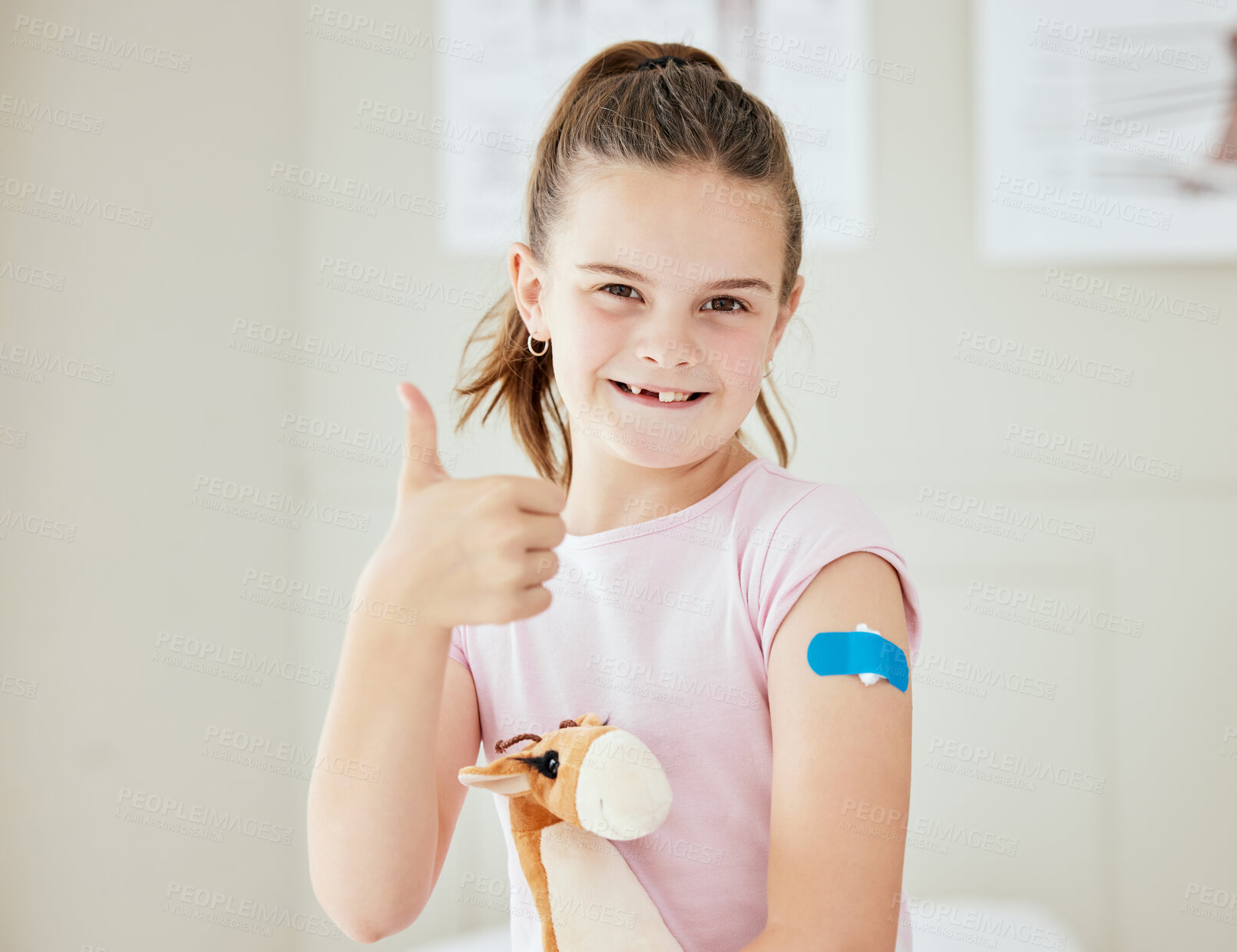 Buy stock photo Shot of a little girl with a bandaid on her arm at a doctor's office