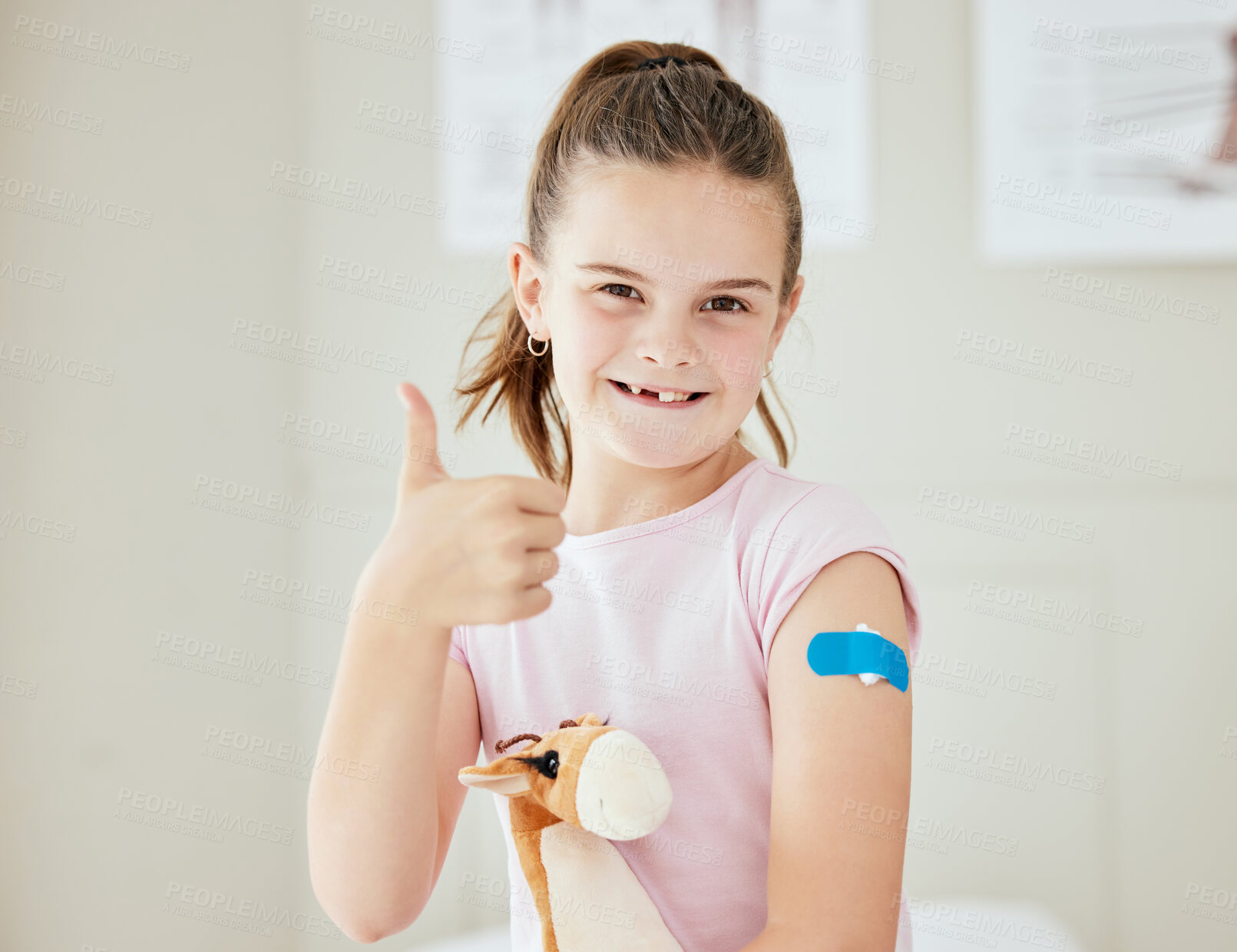 Buy stock photo Girl, thumbs up and portrait in clinic for vaccine, protection and pride for safety in healthcare. Child, teddy bear and hand gesture in practice for wellness, medicare or happy or brave for flu shot