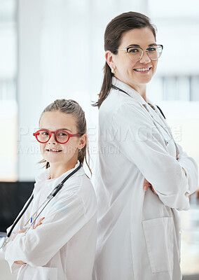 Buy stock photo Shot of a little girl and a doctor standing with their arms crossed at a hospital