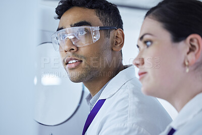 Buy stock photo Shot of two lab workers removing samples from a storage facility