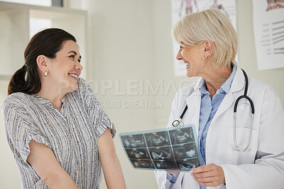 Buy stock photo Shot of a mature doctor showing a patent her ultrasound scans