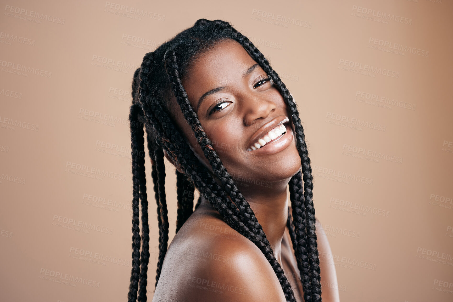 Buy stock photo Cropped portrait of an attractive young woman posing in studio against a brown background