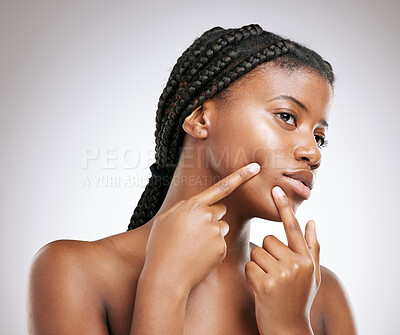 Buy stock photo Black woman, check and pop pimple for acne problem with skincare treatment and smooth texture in studio. African model, girl and face inspection with breakout zit or beauty  scare on grey background