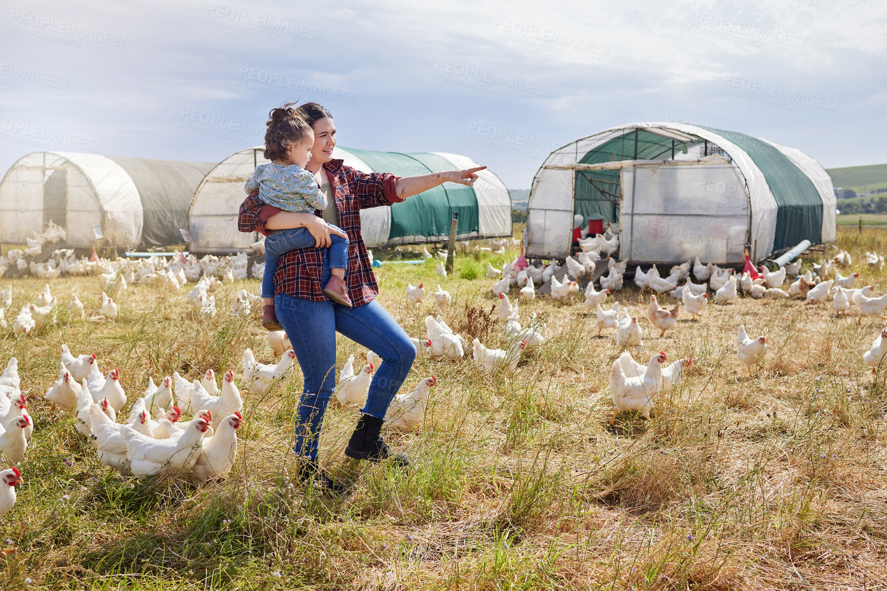 Buy stock photo Shot of a woman bonding with her daughter on a poultry farm