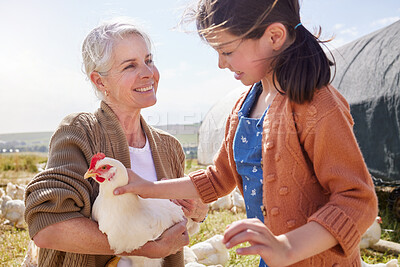 Buy stock photo Shot of a mature woman bonding with her granddaughter on a poultry farm