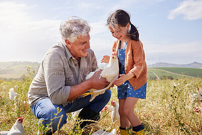 Buy stock photo Shot of a mature man bonding with his granddaughter on a poultry farm