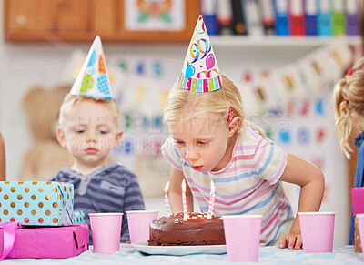 Buy stock photo Blowing candles, birthday cake and students in classroom, celebration and excited with party hat. Kids, education and friends with fun, cheerful and chocolate treat with sweet snack and delicious