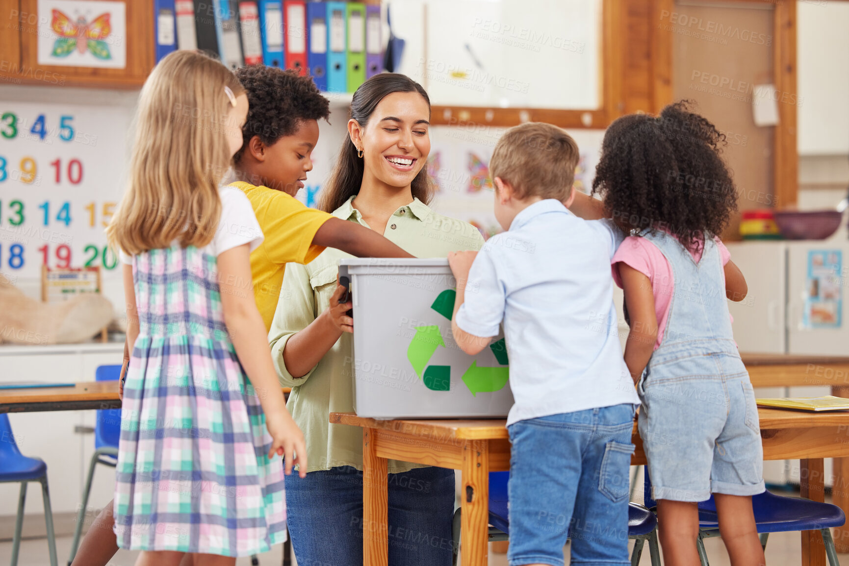 Buy stock photo Shot of a young woman teaching  preschool children about recycling