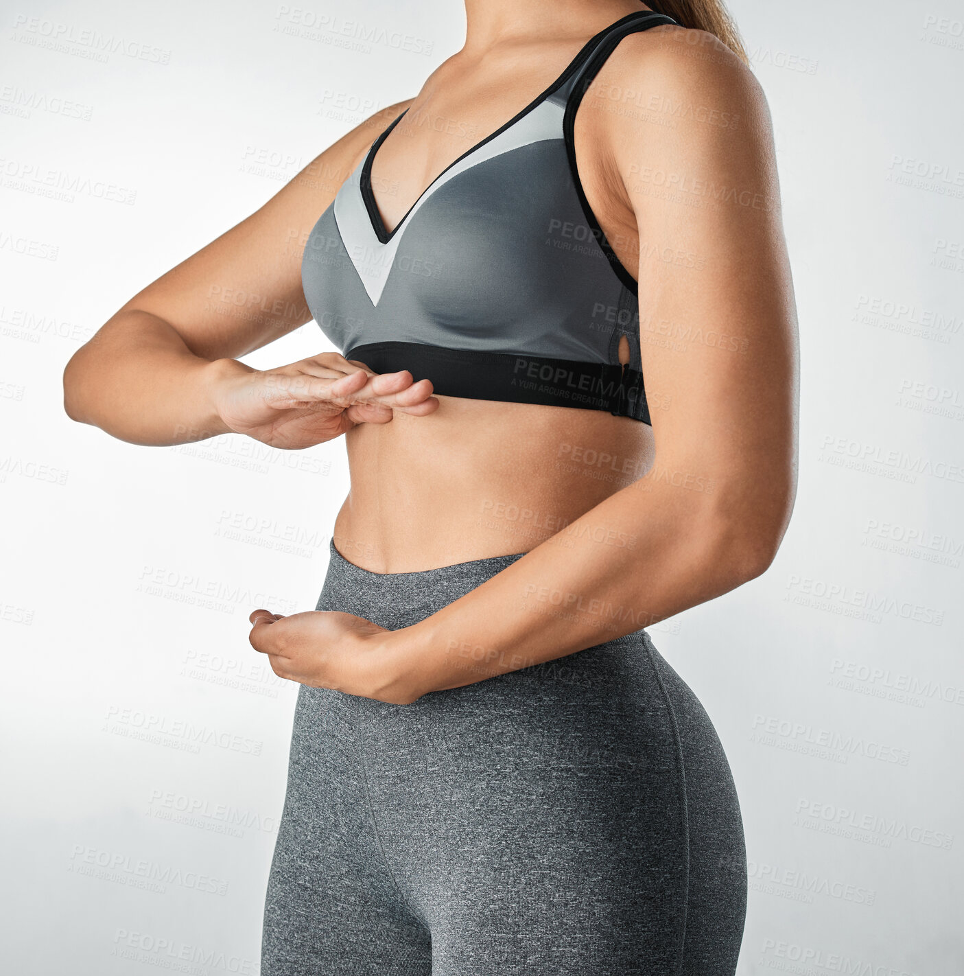 Buy stock photo Studio shot of an unrecognisable woman framing her stomach with her hands against a grey background