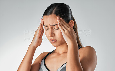 Buy stock photo Studio shot of a sporty young woman experiencing a headache against a grey background