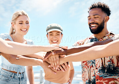Buy stock photo Shot of a diverse group of friends standing together and stacking their hands in the middle
