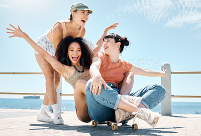 Buy stock photo Full length shot of a diverse group of women bonding while playing with a skateboard outdoors