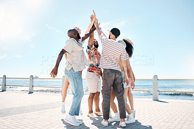 Buy stock photo Full length shot of a diverse group of friends standing and giving each other a high five outdoors