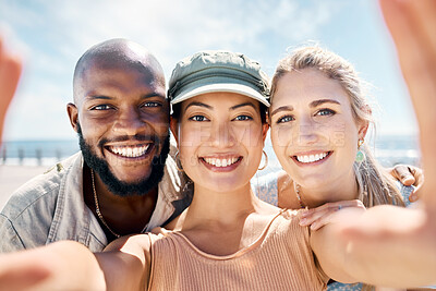 Buy stock photo Shot of a diverse group of friends standing outside together and taking selfies