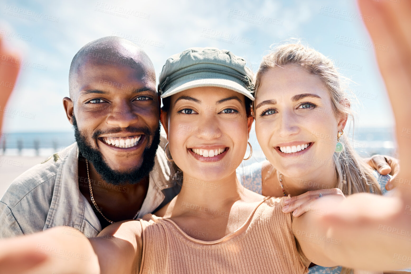 Buy stock photo Shot of a diverse group of friends standing outside together and taking selfies