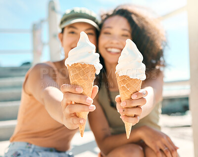 Buy stock photo Cropped portrait of two attractive young girlfriends enjoying ice creams on the beach