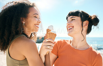Buy stock photo Cropped shot of two attractive young girlfriends enjoying ice creams on the beach