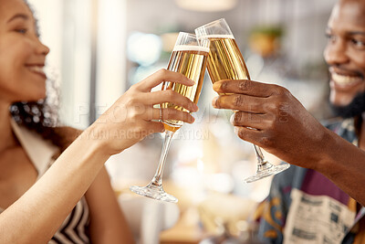 Buy stock photo Shot of a young couple toasting with champagne in a restaurant