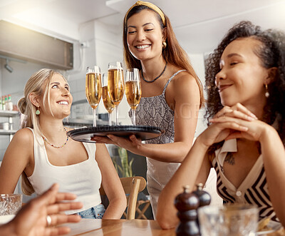 Buy stock photo Shot of a young waitress serving her customers champagne