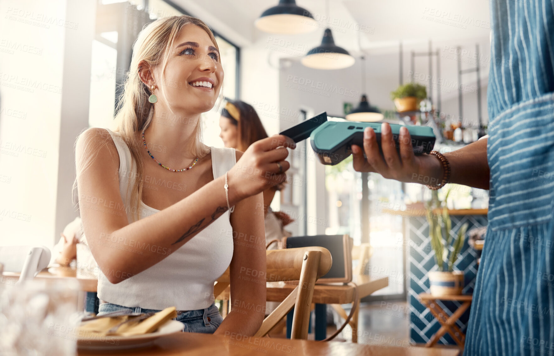Buy stock photo Shot of a young woman making a card payment using a nfc machine