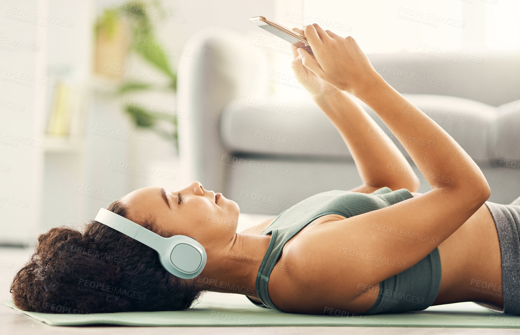 Buy stock photo Phone, relax and yoga woman with music headphones on living room floor for fitness, break or texting at home. Workout, rest and sporty lady with smartphone and earphones for wellness, app or podcast