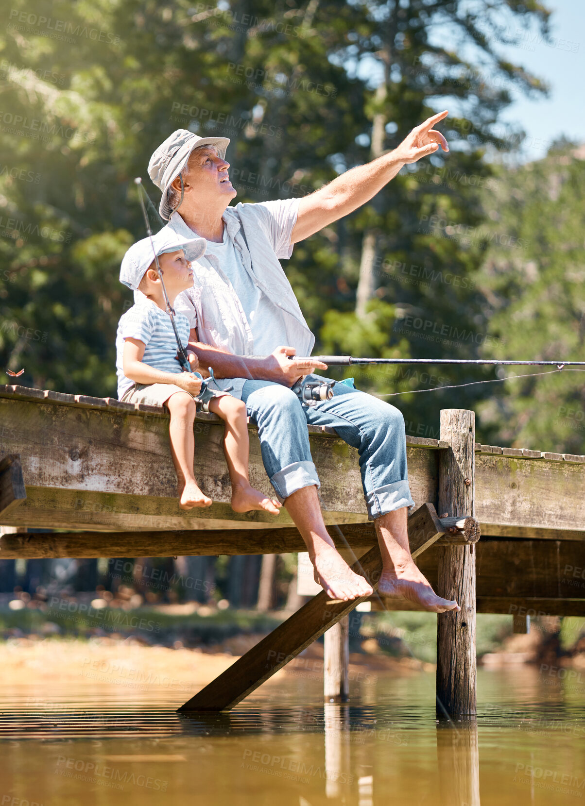 Buy stock photo Grandfather, child and pointing while fishing at lake for fun hobby, adventure and teaching about nature. Boy kid, view and learning to fish with senior man at river, camping trip and happy vacation 