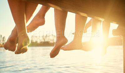 Buy stock photo Group, feet on water and friends together at ocean, pier or outdoor in summer, vacation or freedom in holiday break. Teen, foot and children to relax at the lake, harbor or river on the weekend