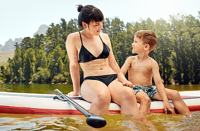 Buy stock photo Lake, woman and boy child on paddle board, relax outdoor with summer holiday and travel. Adventure, freedom with mother and son in swimsuit with feet in water, vacation and family bonding together