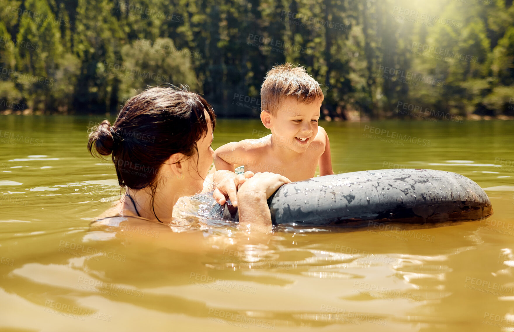 Buy stock photo Travel, float and mother with her child in lake swimming while on a summer vacation or adventure. Happy, tubing and young mom bonding with boy kid in outdoor pond on tropical weekend trip or holiday.