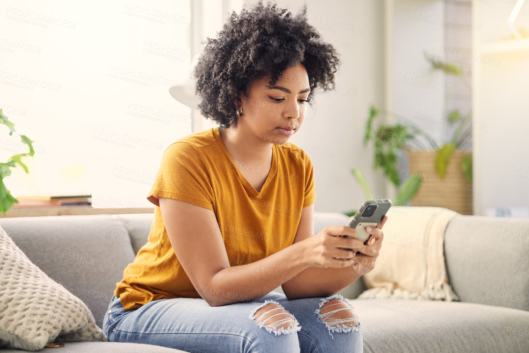 Buy stock photo Phone, relax and woman on sofa in home living room for social media, internet scroll or texting. Mobile, serious or African person on couch in lounge for online app, website or reading email in house