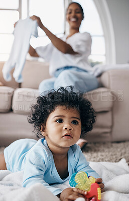 Buy stock photo Shot of an adorable little girl playing with a toy in the living room while her mother watches her