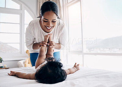 Buy stock photo Shot of an attractive young woman bonding with her baby at home while changing her diaper