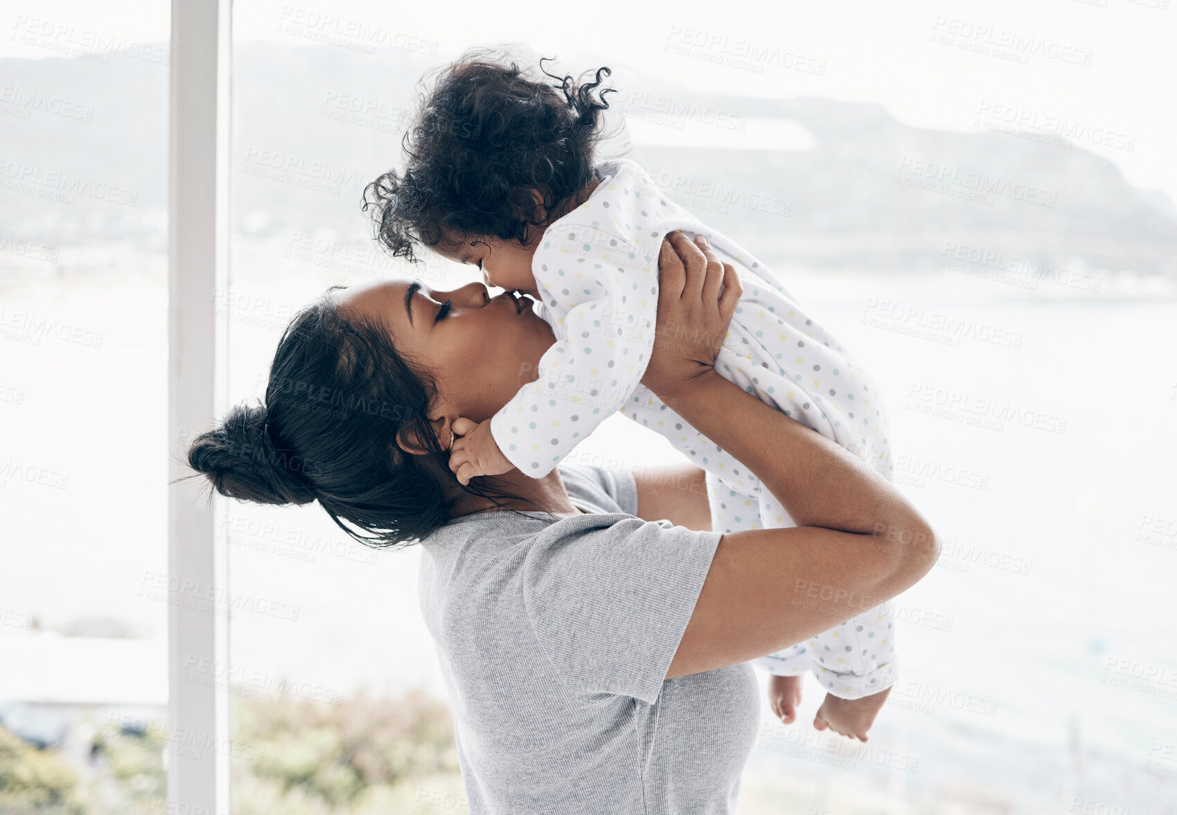 Buy stock photo Bonding, mother and kiss baby in home for security, child development and morning routine by window. Parenting, woman and infant in bedroom with affection, protection and relationship with connection