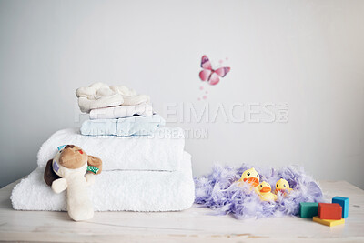 Buy stock photo Laundry, decoration and tidy in nursery bedroom, changing station and stack of towels on furniture. Table, clean linen and pile of clothes in home, fresh textile and maintenance for house hygiene