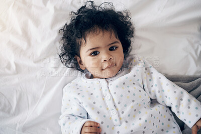 Buy stock photo Shot of a sweet baby girl lying on a bed at home