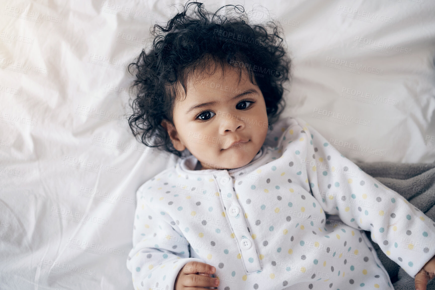 Buy stock photo Shot of a sweet baby girl lying on a bed at home